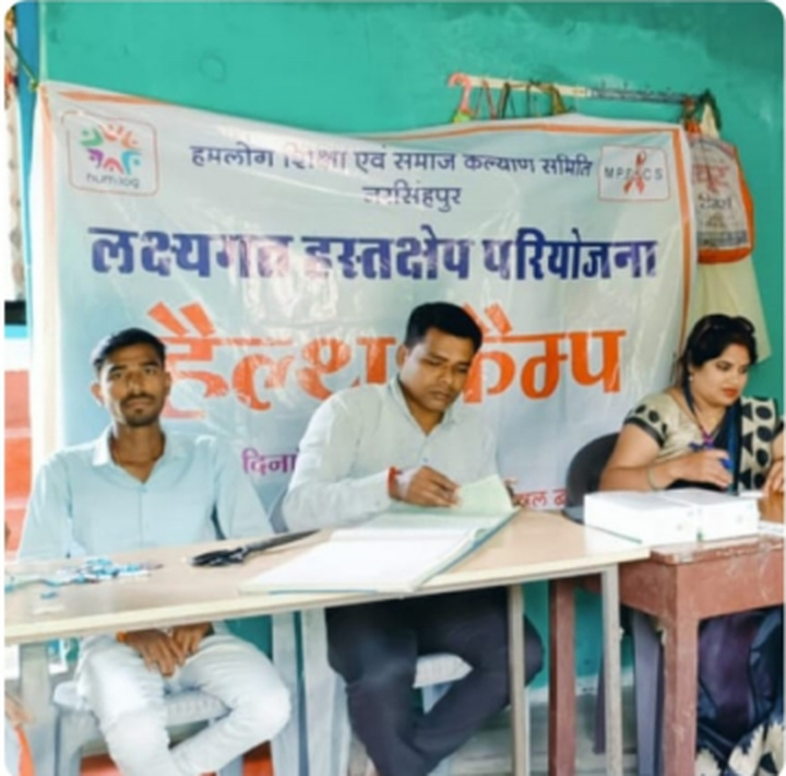 Health workers seated at the consultation desk during the community health camp.