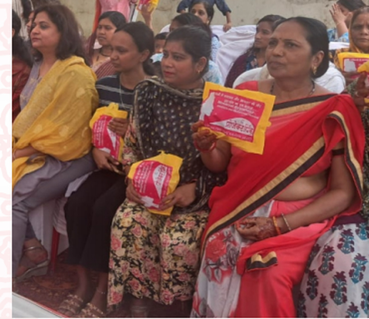 Women holding sanitary napkin packs during the menstrual health awareness programme.