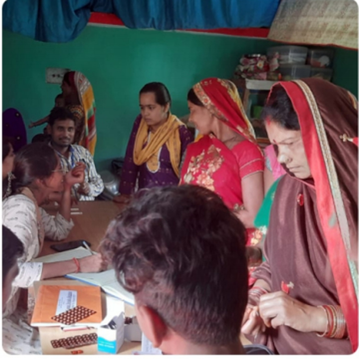 Women speaking with health workers during the community health camp.
